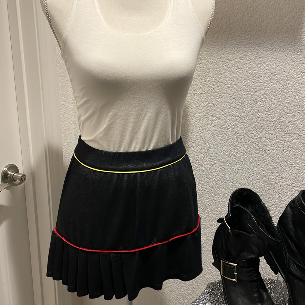 Tail 13.5” skort. Pleated and trimmed with yellow and red. Has yellow skort Sz S